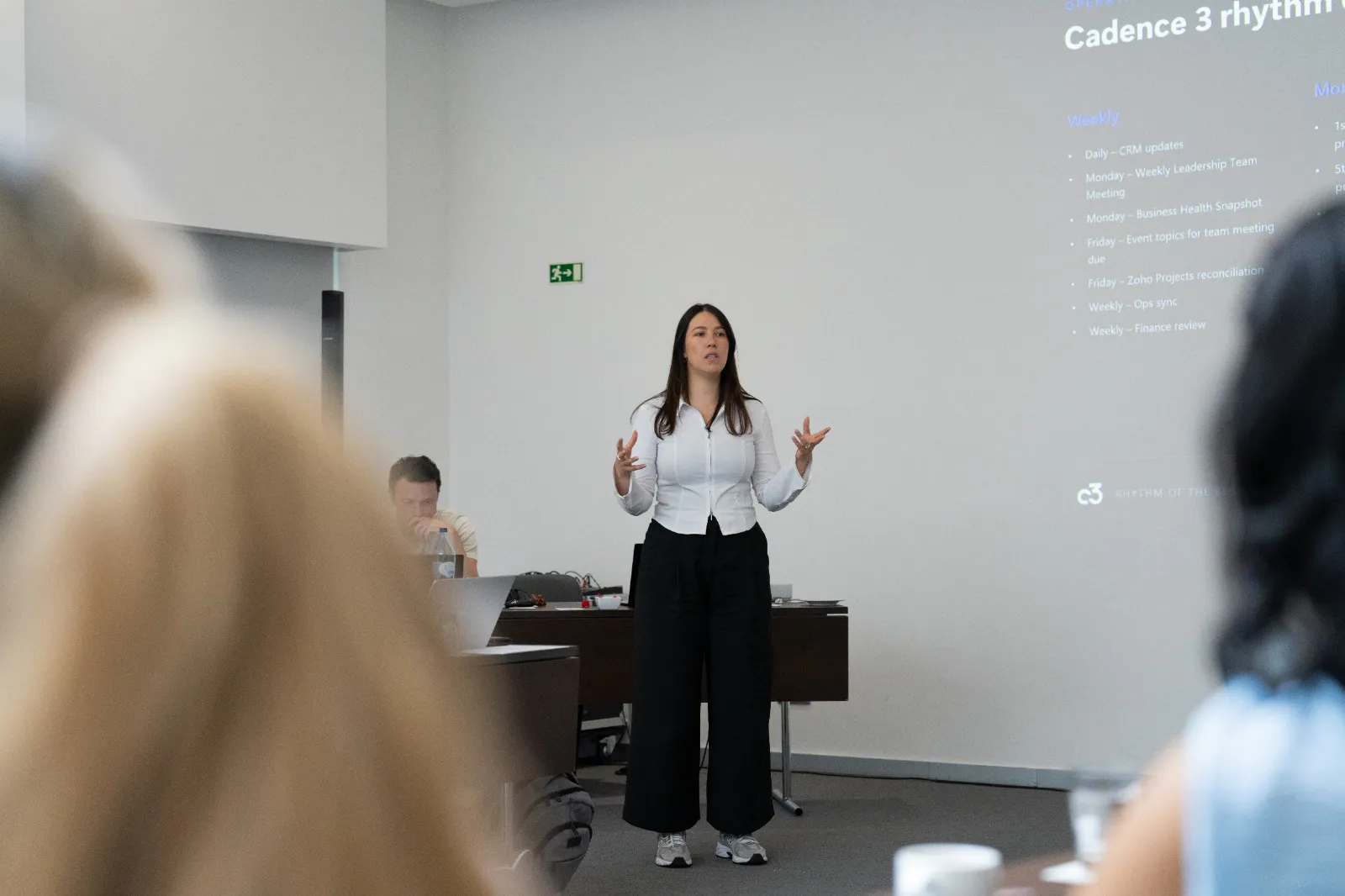 A Cadence 3 team member presenting the agency operating rhythm to colleagues in a bright meeting room.