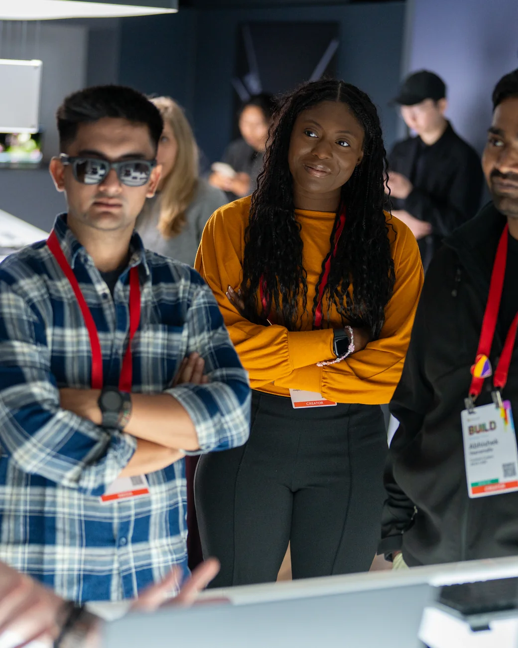 Two guests at a hands-on session, lanyards on, mid-conversation beside the display.