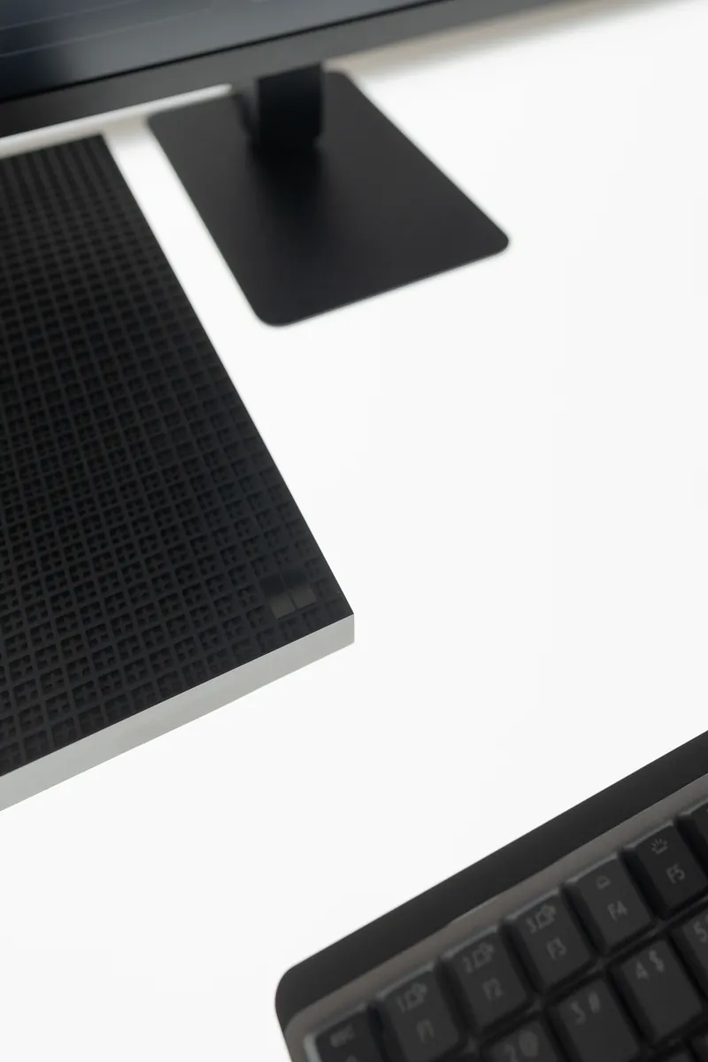 Macro detail of a device edge and keyboard against a bright white backdrop.