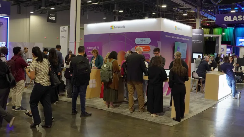 A wide view down the Microsoft stand, attendees moving between the demo counters.