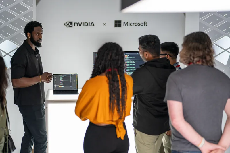 Four people in conversation in front of the NVIDIA and Microsoft wall.