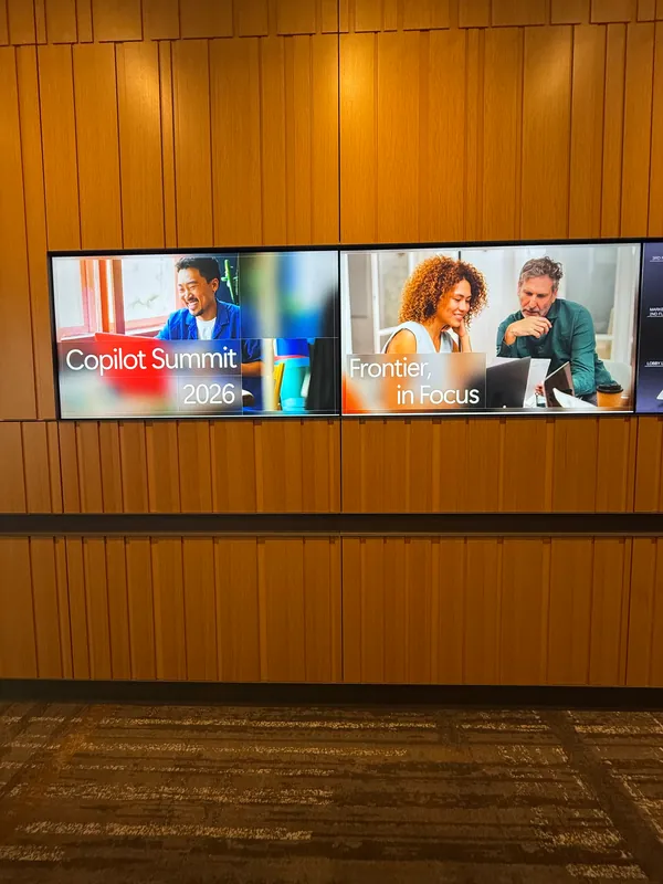 A timber-panelled wall carrying the Copilot Summit screen at the entrance to the space.