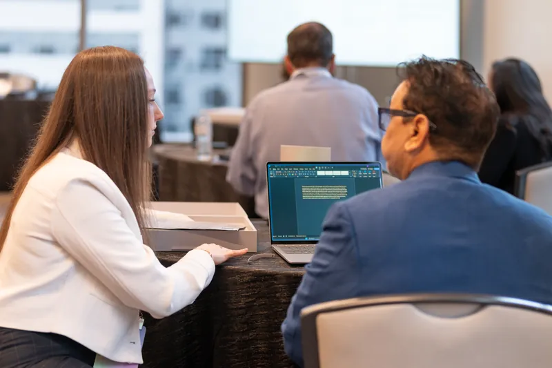 Attendees working together at a table during a session break.