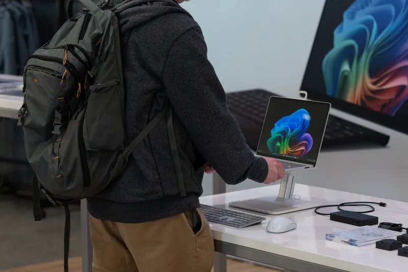 A visitor reaching across the device table, all-in-one screens lined up behind.