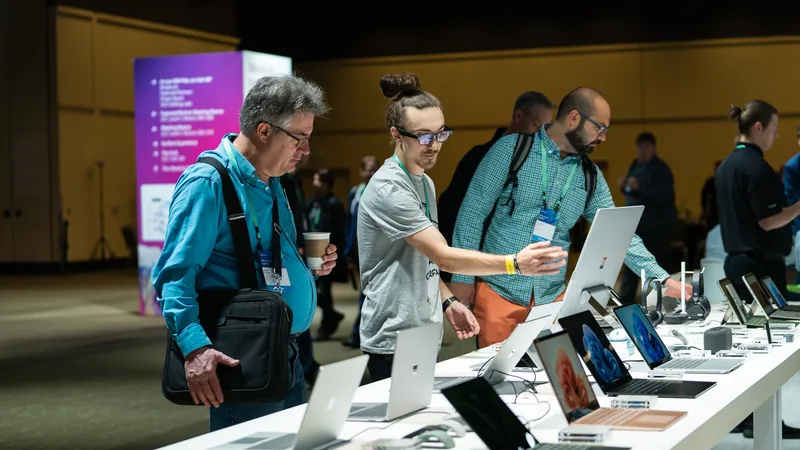 The stand at its busiest, attendees three deep along the device tables.
