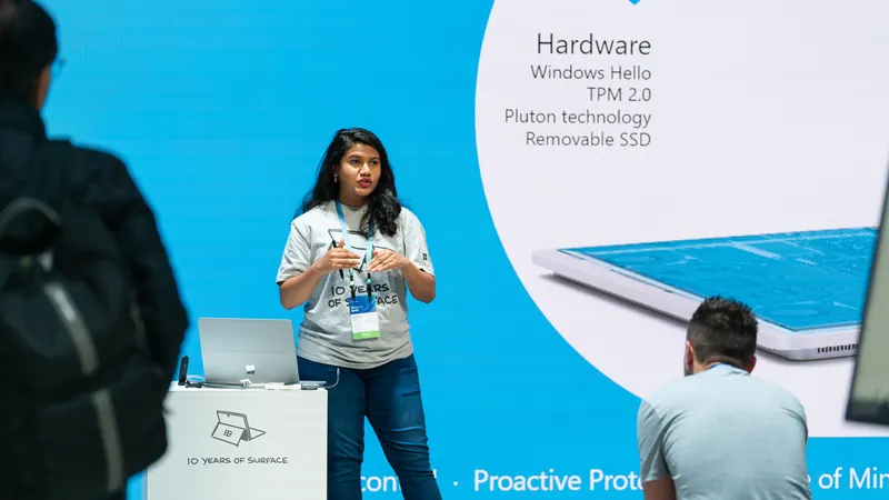 A presenter beside a slide setting out the hardware security stack.